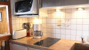 Eine Küche mit Mikrowelle, Toaster, Kaffeemaschine und Spüle.