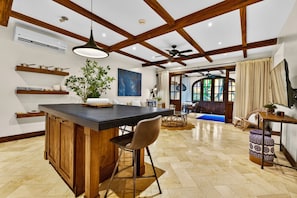 Una cocina con isla central, vigas de madera y ventilador de techo.
