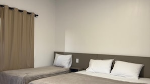 A hotel room with two single beds, beige curtains, and a neutral color scheme. - Hotel Jatobás Sinop (Sinop)