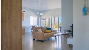 A spacious living room with a beige sofa, a coffee table, and a dining area with chairs. - Ocean View 3 bed, 3 bath. Private pool. Steps to the beach in gated community (Peadsi)