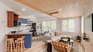 Une cuisine moderne avec des meubles en bois, un îlot central et des tabourets de bar.