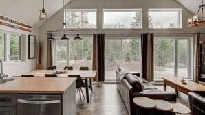 Una cocina moderna con comedor, ventanas amplias y un rincón de descanso acogedor.