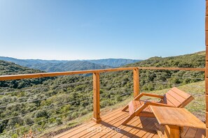 Eine Holzterrasse mit Blick auf eine gebirgige Landschaft.