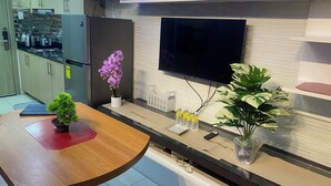 Una cocina moderna con televisor integrado, una mesa de comedor y diversos electrodomésticos.