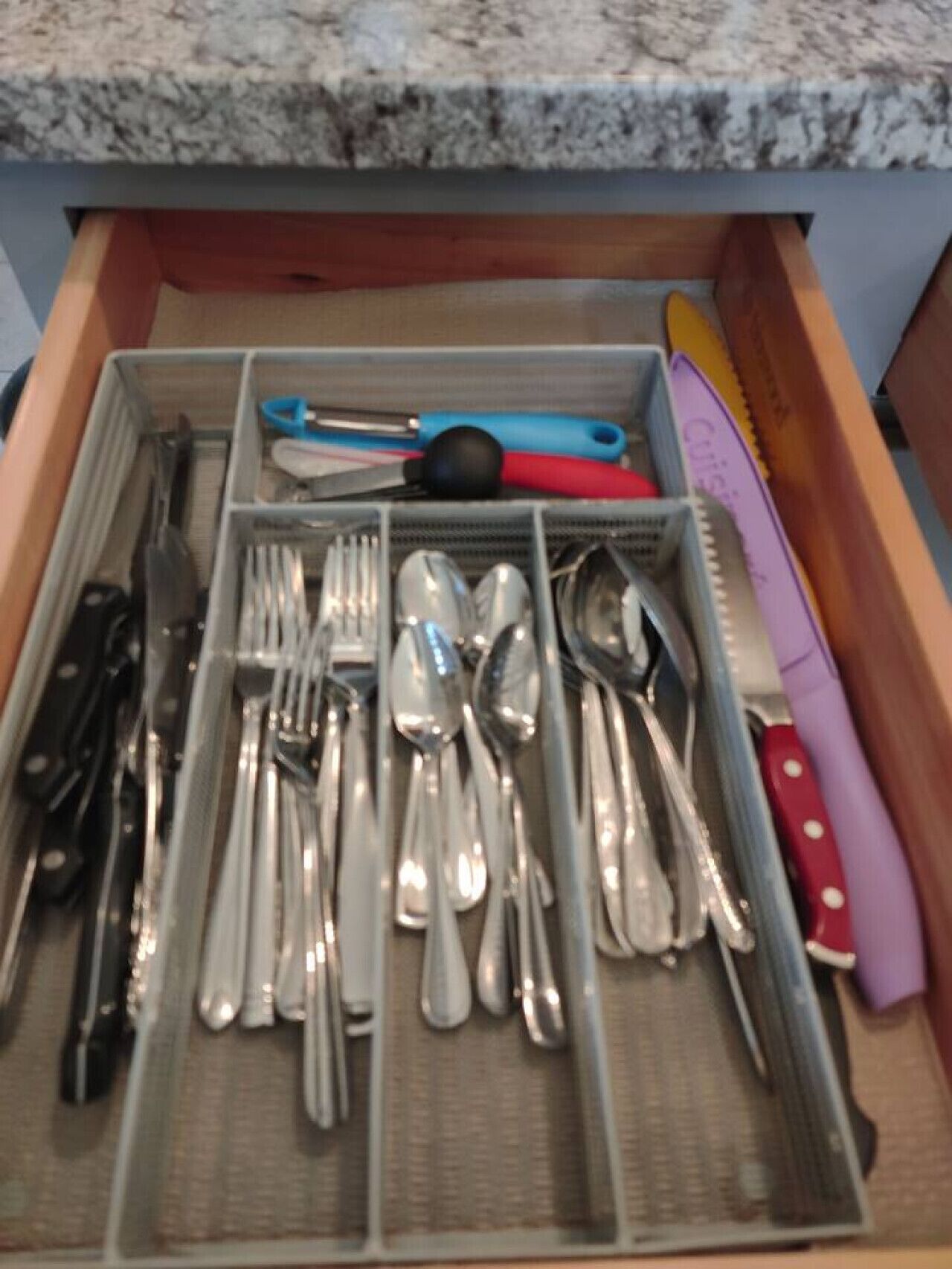A drawer with neatly organized utensils including forks, knives, and spoons.