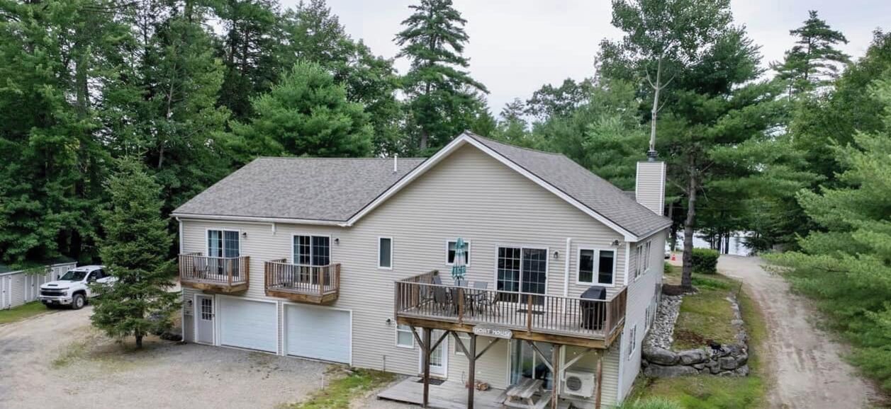 A two-story house with a balcony, a garage, and a porch.
