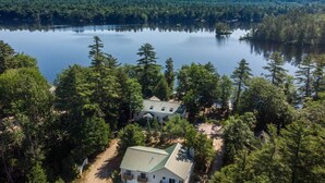 Ein Haus, umgeben von dichtem Wald, mit einem See im Hintergrund.