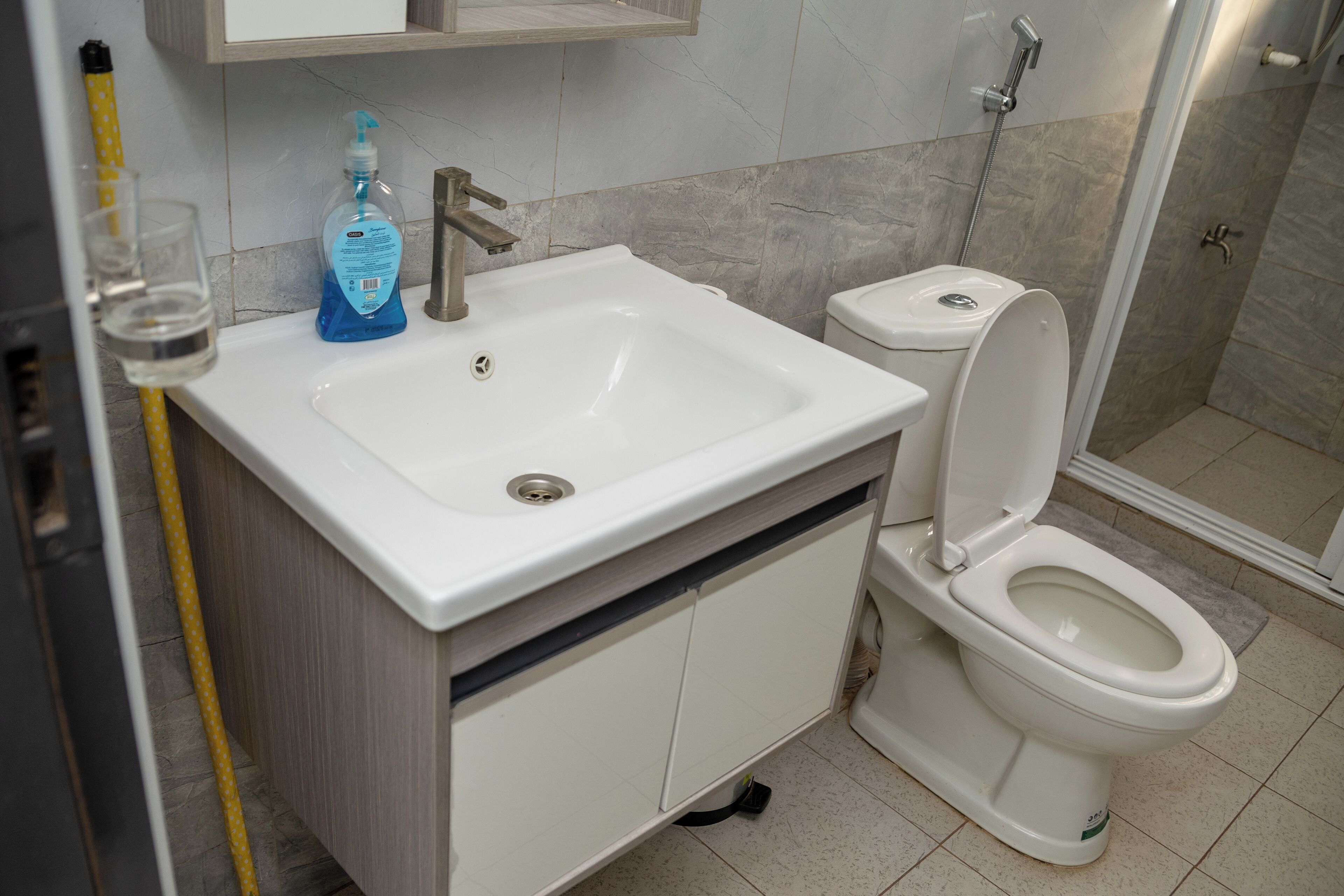 A bathroom with a white sink, a toilet, and a shower area.