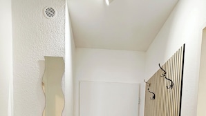 A hallway with wooden flooring, a white door, and a radiator on the right. - A time-out in the city center (Osnabrück)