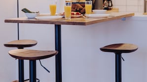 A kitchen with a wooden countertop, two bar stools, and a coffee maker. - A time-out in the city center (Osnabrück)