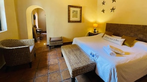 Una habitación de hotel acogedora con una cama, muebles de mimbre, una mesita y una pared decorada con estrellas.