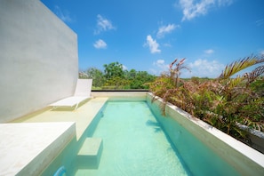 Una piscina al aire libre, camas de piscina gratis, sombrillas