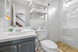 Ein modernes Badezimmer mit Waschbecken, Toilette und Duschbereich.