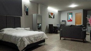 Ein Hotelzimmer mit Bett, Schreibtisch, Sessel und einer Couch.