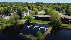 An aerial view of a residential area with houses, a dock, and a small body of water. - Juniper Motel-Double Queen-RM4-Pet Friendly*ATV Access*Lakefront (Greenville)