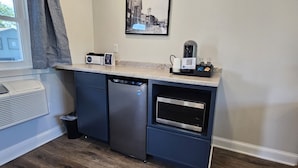 A compact kitchen with a dishwasher, microwave, and coffee maker on the counter. - Juniper Motel-Double Queen-RM4-Pet Friendly*ATV Access*Lakefront (Greenville)