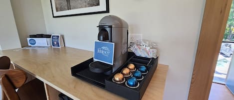 A coffee machine with a branded coffee pod holder and a sign for The Juniper Motel.