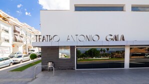 La entrada al Teatro Antonio Gama, con una fachada moderna, grandes ventanales y una vista despejada de la calle y los edificios circundantes.