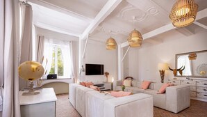 Een ruime woonkamer met een grote modulaire bank, een flatscreen televisie en een open haard.