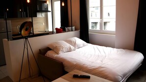 A bedroom with a bed, a desk, a chair, a mirror, and a window. - Downtown Living With a View, Ideal for 4 (Le Mans)