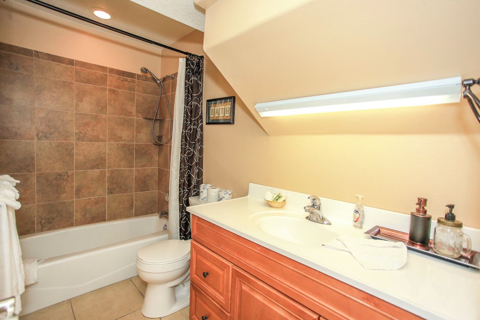A bathroom with a bathtub, toilet, vanity with a sink, and a shower.