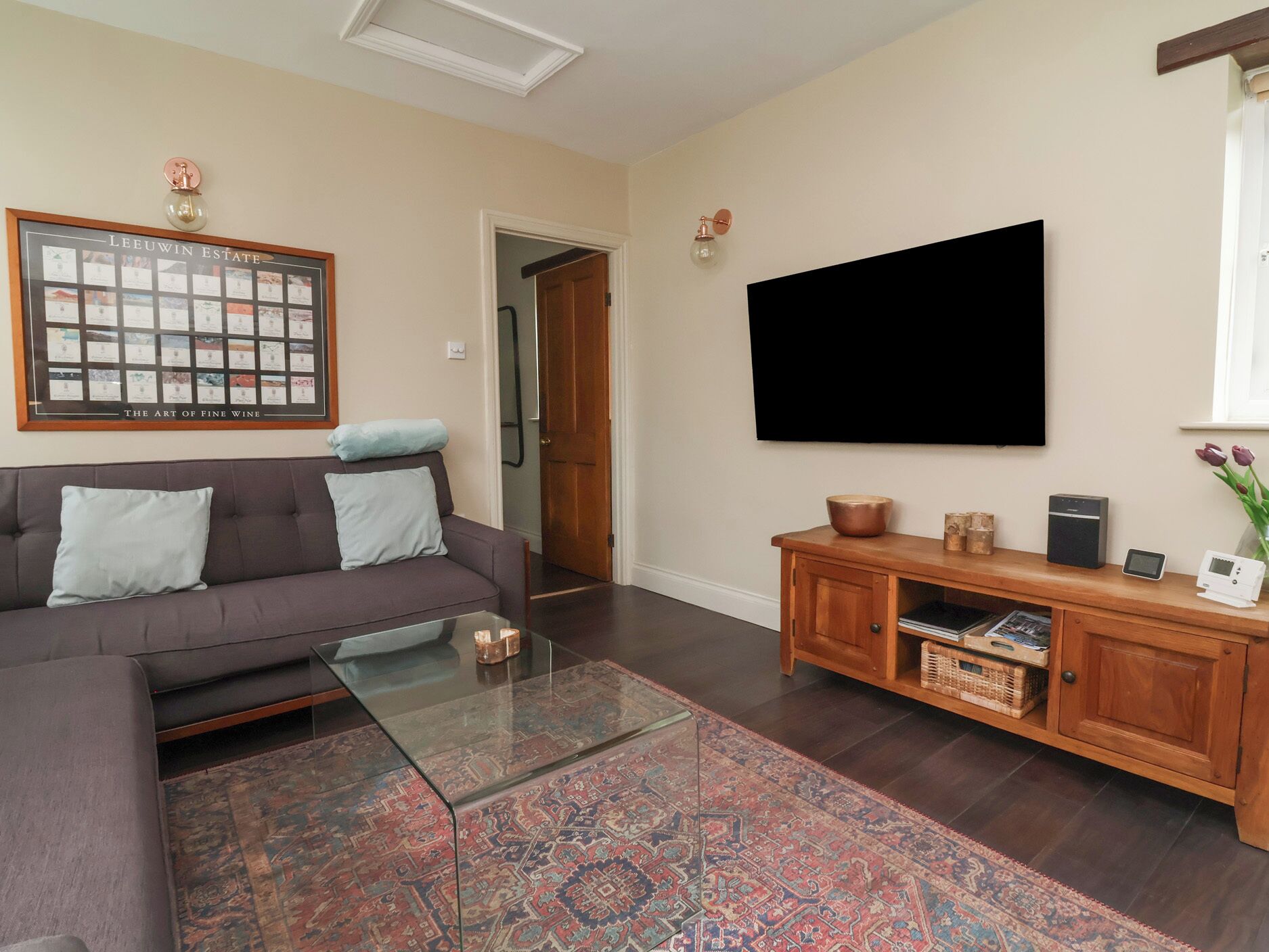 A living room with a sofa, coffee table, TV, and a wooden cabinet.