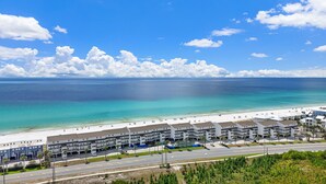 Un hôtel situé sur la côte, composé de plusieurs bâtiments à étages, donnant sur la plage et offrant une vue dégagée sur l’océan.