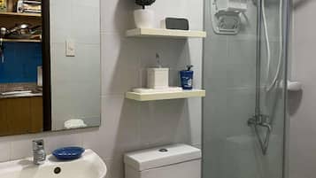 Een douche, een bidet, handdoeken, toiletpapier