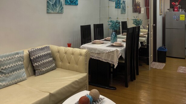 A modern living room with a sofa, dining table, and chairs. There are wall art pieces and a chandelier. - Casa Z - Bali Oasis Phase 2 (Pasig)