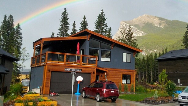 A two-story house with a garage labeled "River's Bend Drive".