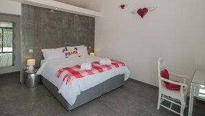 A modern bedroom with a bed, bedside lamps, a chair, and decorative wall art. - Noflash Malpal (Bristol)
