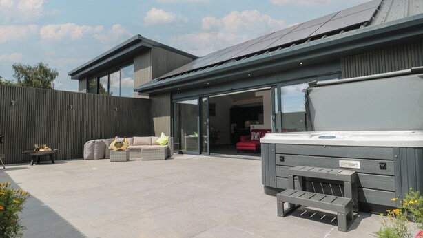 A modern house with a patio, outdoor seating, and a hot tub. - Noflash Malpal (Bristol)