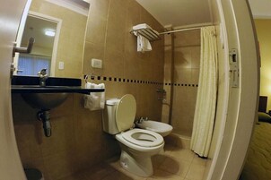 Un baño con inodoro, lavamanos y ducha.