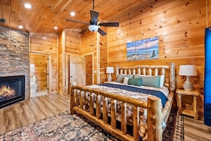 Log bed frame with a fireplace at the foot of it