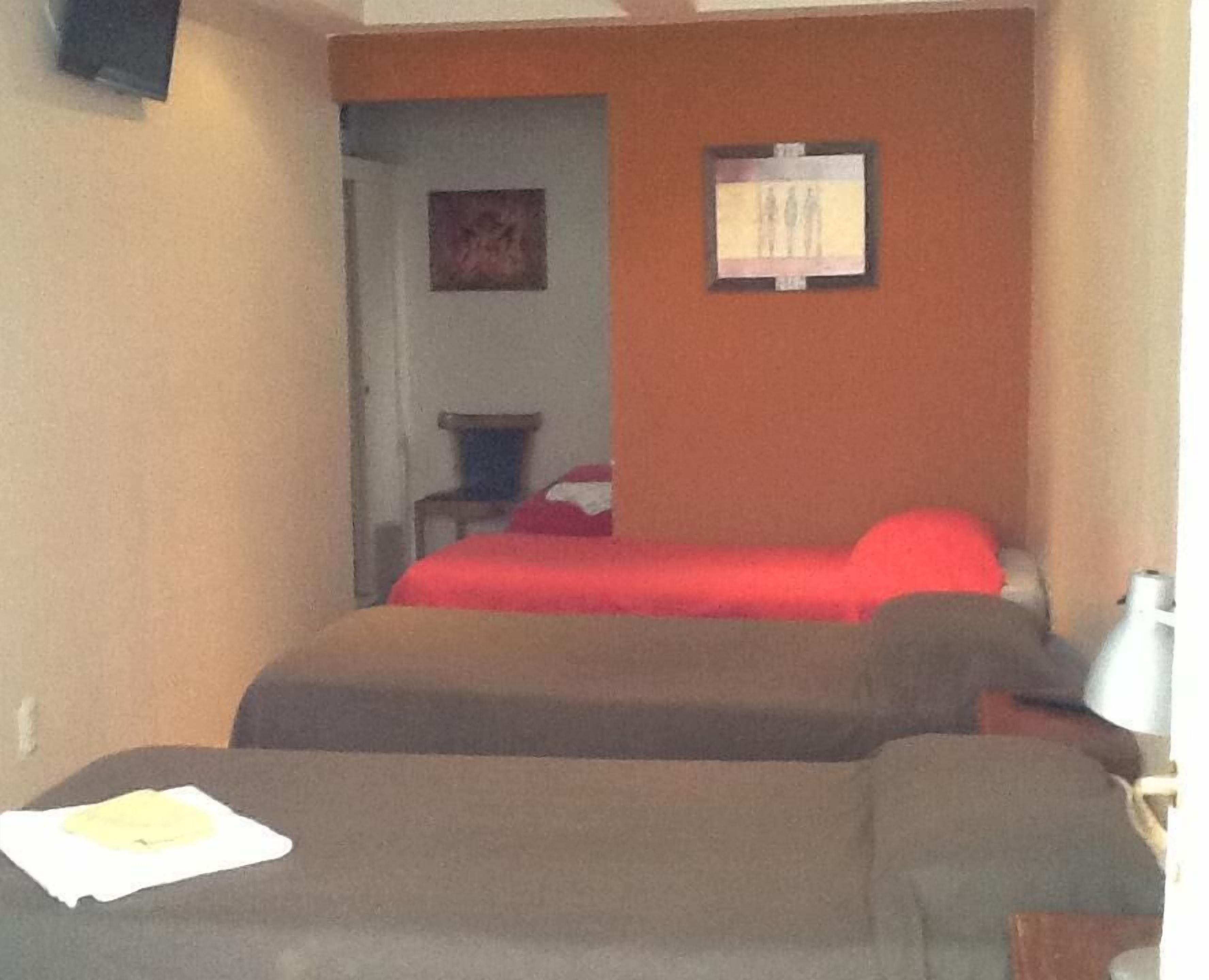 Una habitación pequeña y funcional con cama, una silla y escritorio.