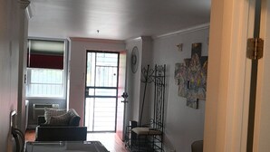 Un salon spacieux doté d’un plancher en bois franc, d’une grande fenêtre et d’une cheminée.