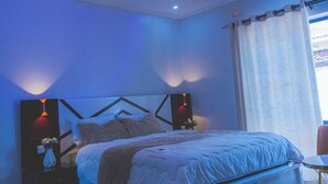 A bedroom with a bed, bedside tables, a ceiling fan, and a window with curtains.