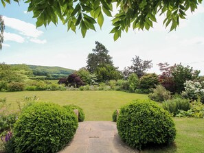 A garden pathway leading to a lawn with various shrubs and trees. - Uplands Dower House (Ledbury)