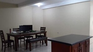 A dining area with a table and chairs, a bench, a TV, and a small cabinet. - Luxurious Sea View From The Pool (Gulf View)