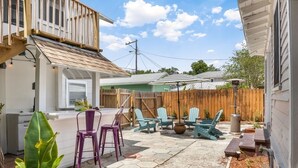 A backyard with a patio, seating area, and a wooden fence.
