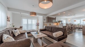 A modern living room with a sectional sofa, a coffee table, and pendant lighting. - Comfort Four Bedroom Villa with Sea View and Private Pool ( Villa 7) (Debeljak)