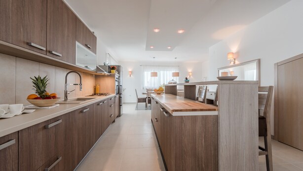 A modern kitchen with wooden cabinets, a central island, and pendant lighting. - Comfort Four Bedroom Villa with Sea View and Private Pool ( Villa 7) (Debeljak)