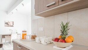 A modern kitchen with a wooden countertop, a bowl of fruit, and a coffee station. - Comfort Four Bedroom Villa with Sea View and Private Pool ( Villa 7) (Debeljak)