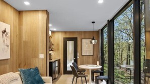 Una sala de estar moderna con un sofá, una mesa de comedor con sillas y una cocina al fondo.