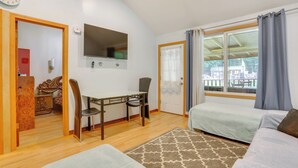 Ein Zimmer mit einem Bett, einem Schreibtisch, einem Stuhl, einer Uhr und einem Fenster mit Vorhängen.