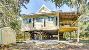 A two-story house with a covered porch and a detached garage. - Walk to Lake George: Quiet Nature Escape w/ Deck (Fort McCoy)