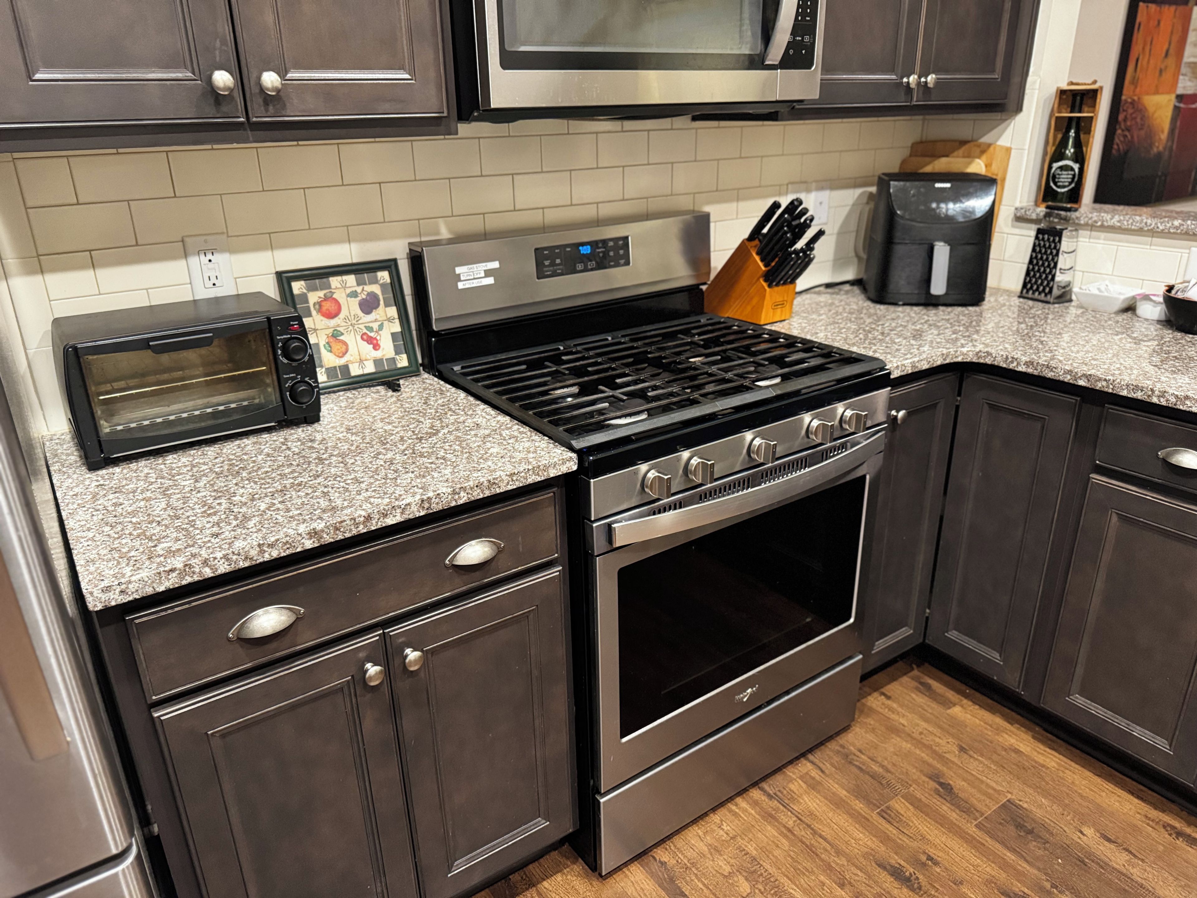 A kitchen with a built-in oven, a stovetop, a microwave, and a toaster.