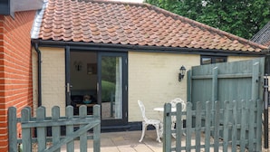 A house with a tiled roof, a brick wall, and a wooden gate.