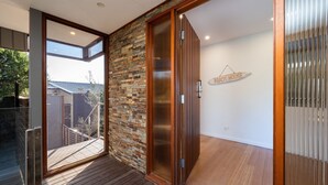 Un interior moderno con piso de madera, pared de piedra y puerta corredera.