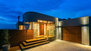 A modern house with a curved roof, a stone facade, and a wooden front door. - Pet Friendly - Hopewell House with Spa and Golf Course Views (St Andrews Beach)